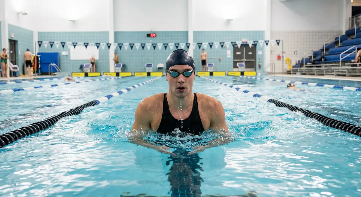 سباح يقوم بتمرير الحركة في الماء بدقة مع تركيز على تقنية القدم