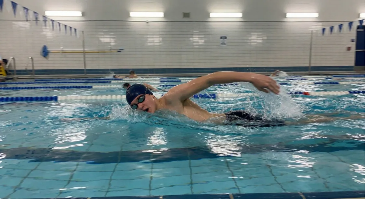 سباح يقوم بتمرير دقيق للحركة في الماء إلى زميله في حوض السباحة